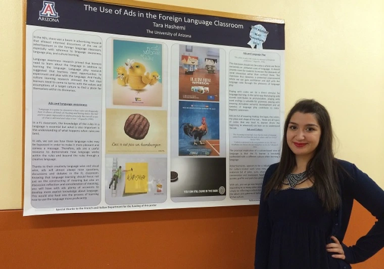 Tara Hashemi standing in front of winning poster